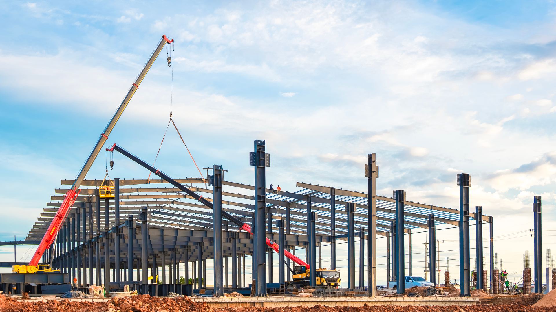 Montagem de estrutura metálica de pavilhão industrial com gruas